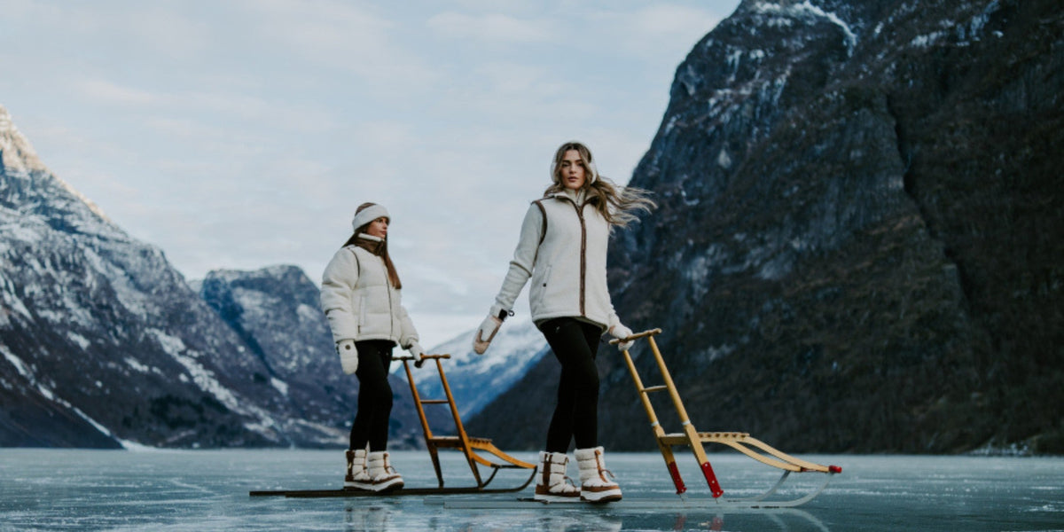 To kvinner med kjelker på frossen fjord