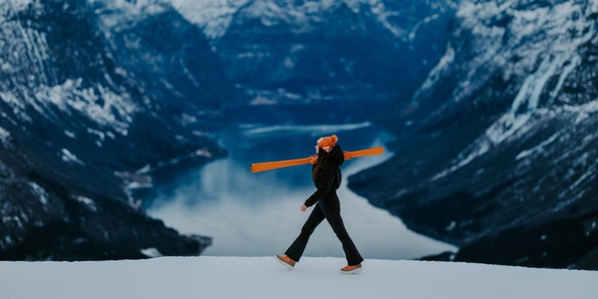 Person går med ski over snøen med fjordpanorama i bakgrunnen