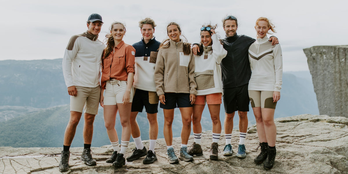 Stor gruppe turgåere samlet på Preikestolen med Lysefjorden i bakgrunnen